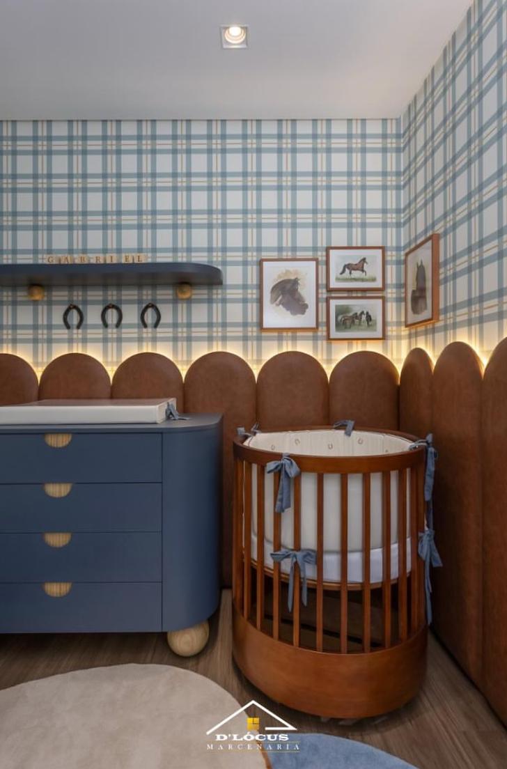 Quarto de bebê com cômoda curva azul, berço redondo de madeira e painéis estofados, projeto D'Lócus