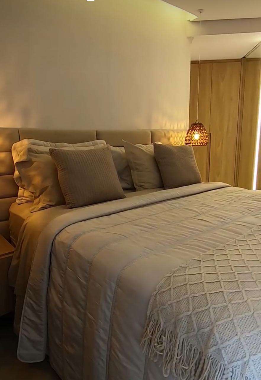 Suíte com cabeceira estofada, roupeiro de madeira e luminária de fibra natural, em clima aconchegante, projeto D'Lócus